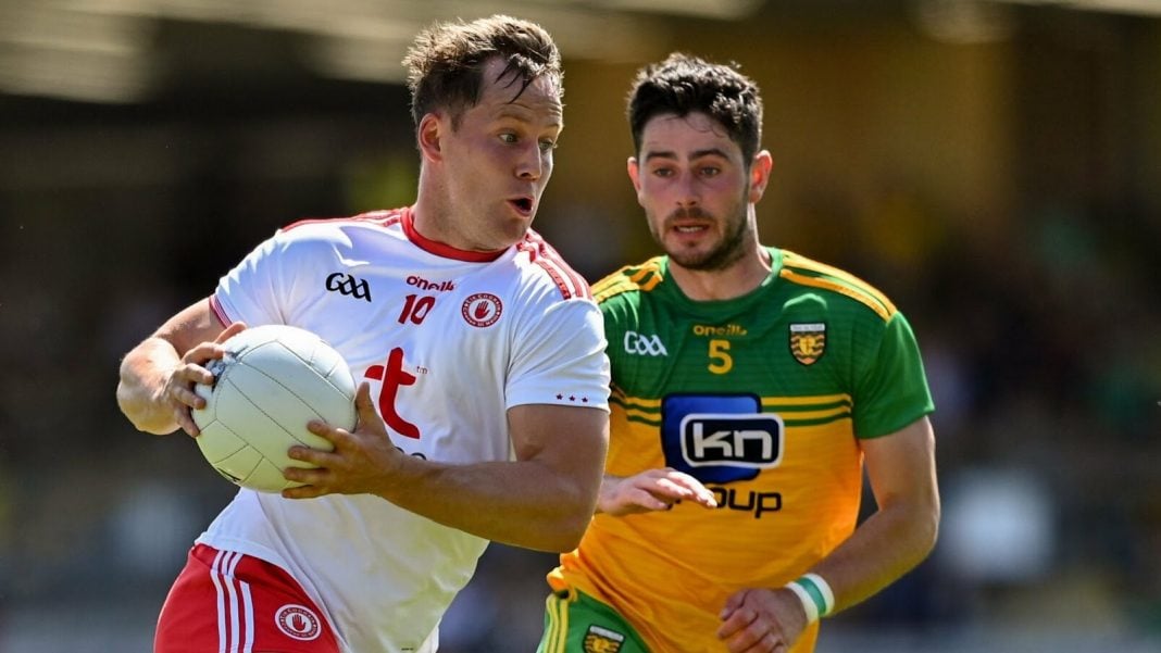 Tyrone GAA footballer trying to avoid a Donegal tackle