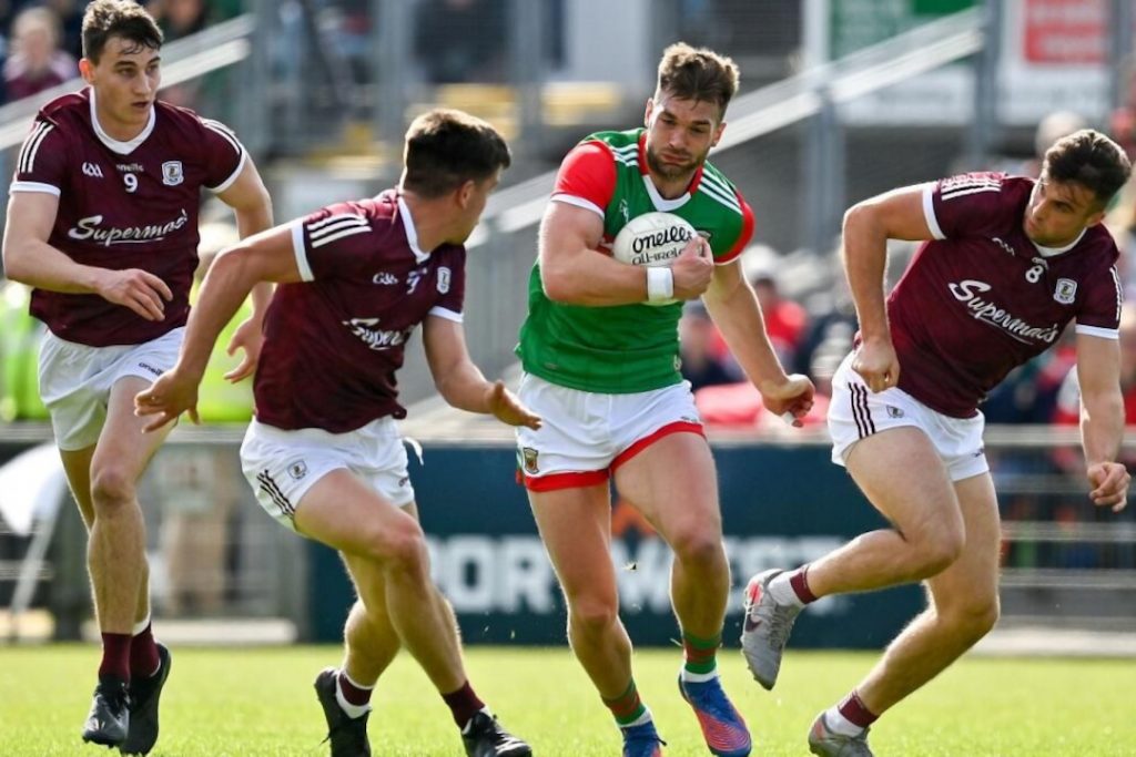 Mayo player running past Galway defenders