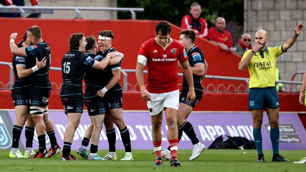 Glasgow players cheer while a Munster rugby player hangs his head in shame 