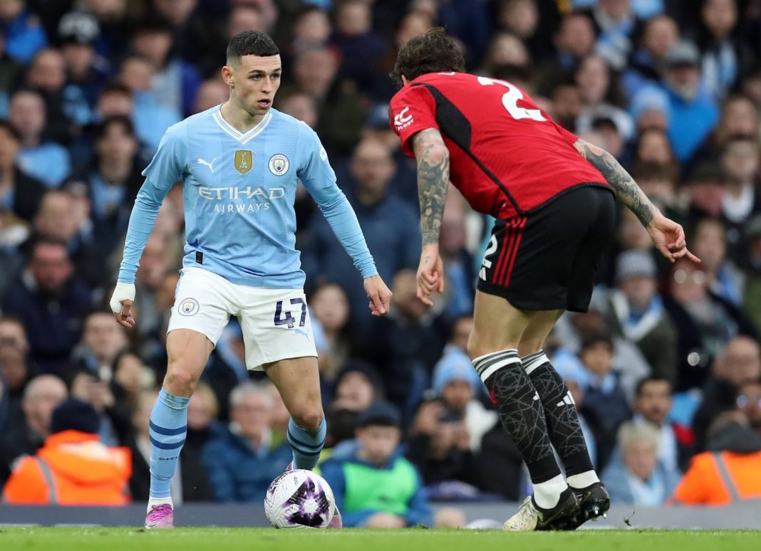 Phil Foden squaring up with the ball to a Manchester United defender